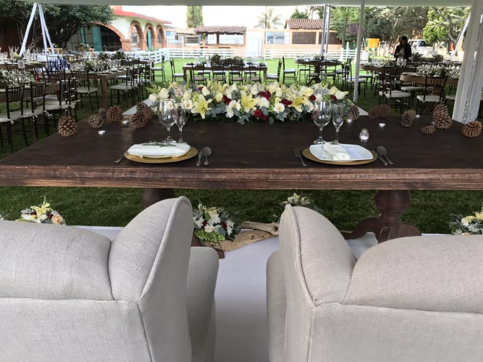 Mesa principal de novios con candelabros y flores, lista para una boda íntima con mesas imperiales al fondo