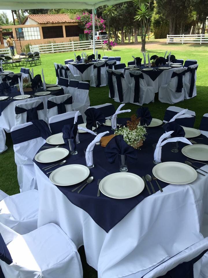 Montaje formal en azul marino con sillas cubiertas blancas bajo carpa para evento social en Rancho San Antonio
