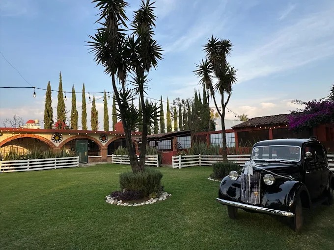 Auto clásico vintage negro frente a la fachada de arcos del Salón de Trofeos de Rancho San Antonio