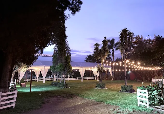 Jardín de noche con carpa blanca y fairy lights entre los árboles, creando una atmósfera mágica para bodas en Cholula